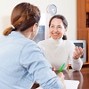 Image d'une femme senior qui répond aux questions de son interlocuteur d'aide à domicile